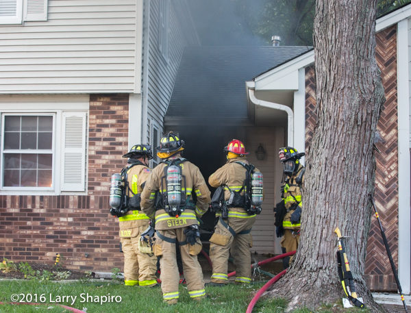 heavy smoke from front door of house on fire