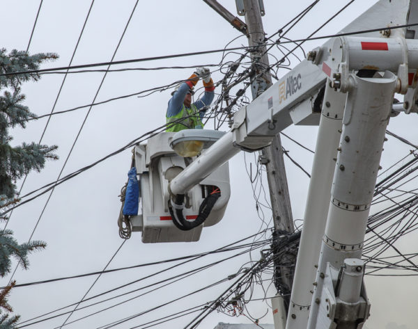 utility worker in bucket with power lines