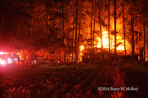 mobile home engulfed in flames at night in rural area