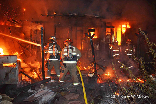 firefighters battle mobile home fire at night