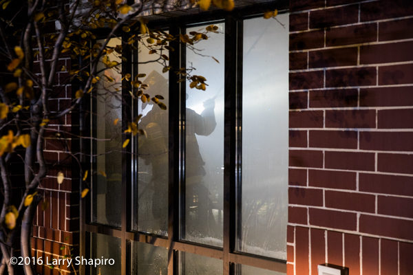Firefighter seen in smokey room through window