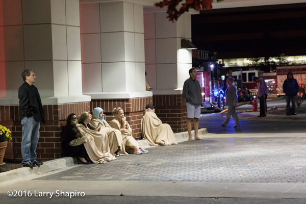 hotel guests wrapped in blankets outside hotel