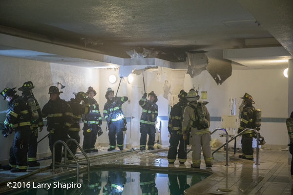 firefighters overhaul after fire near indoor pool