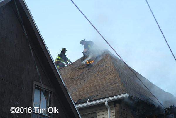 Firefighters venting a house roof