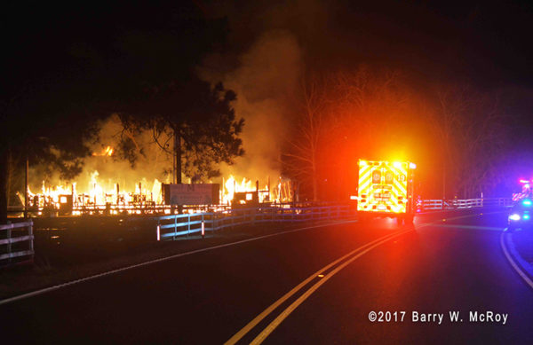 firefighters battle barn fire at night