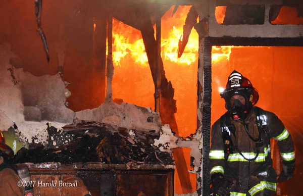 firefighter with PPE exiting burning building