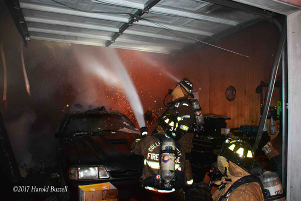 firefighters with hose line in garage
