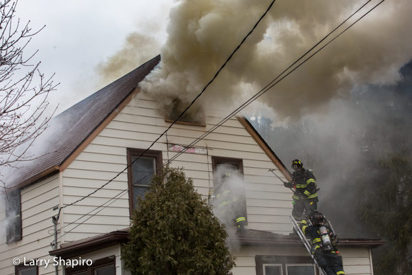 heavy smoke from attic of house on fire