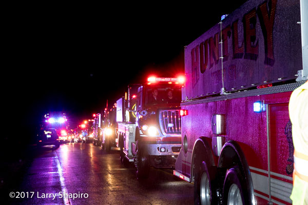 many fire department water tenders in line at a fire scene
