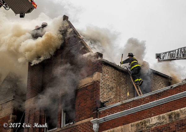 Firefighter on roof with heavy smoke