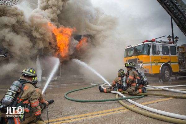 firefighters battle fire with heavy smoke and flames