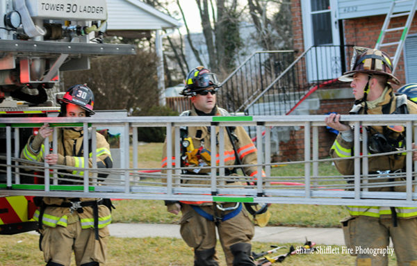 firefighters carry ground ladder