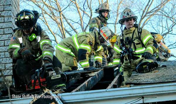 firefighters overhaul roof after fire