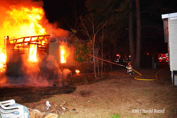 firefighter battles rural house fire at night