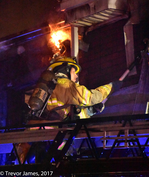 firefighter on aerial ladder at night
