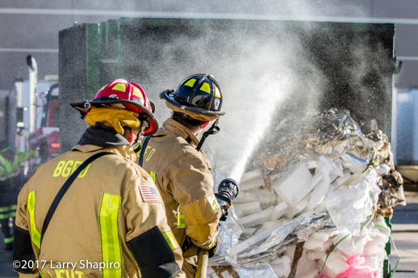 Firefighters soak contents of dumpster after a fire