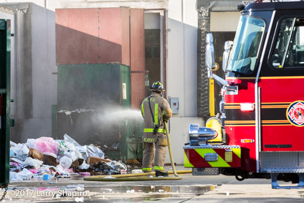 Firefighter soaks contents of dumpster after a fire
