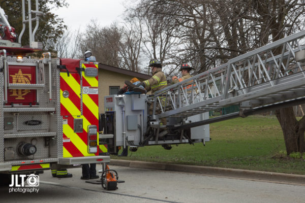 firefighters remove patient in tower ladder platform