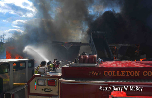 firefighter operates deck gun at fire scene