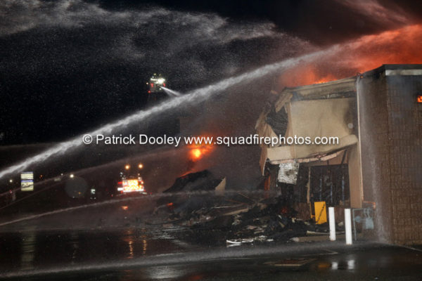 firefighters battle fire that destroyed a commercial business at night