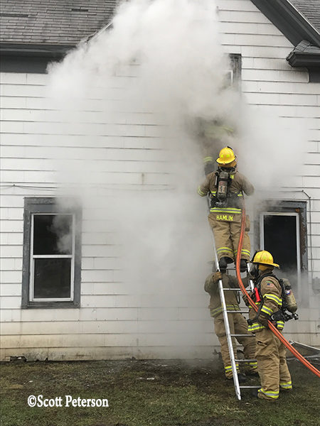 firefighters on ladder at house fire