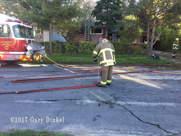firefighter rolls hose after fire