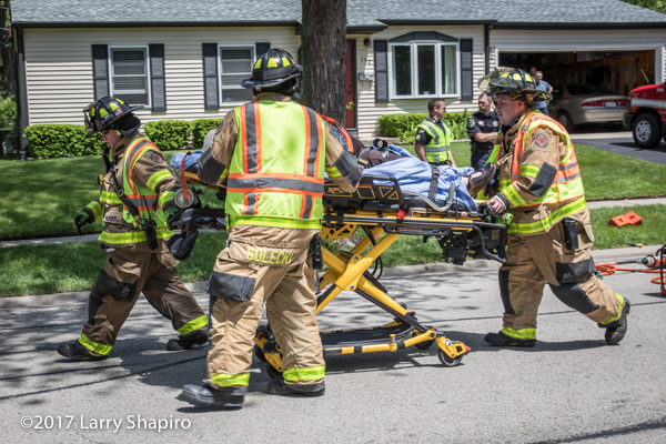 Firefighters move patient on Stryker cot