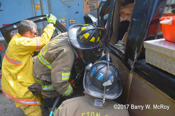 firefighter uses Holmatro spreader at crash site