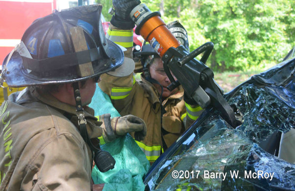 firefighters use Holmatro cutters at a crash site