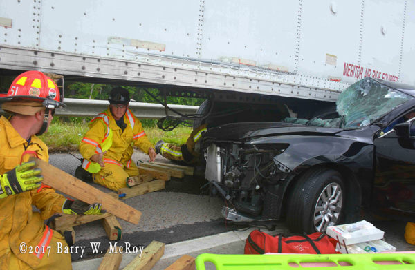 firefighters use cribbing to lift trailer from car
