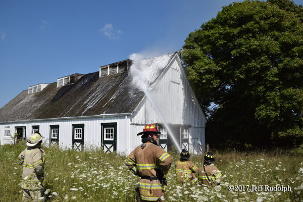 Firefighters apply foam to protect barn