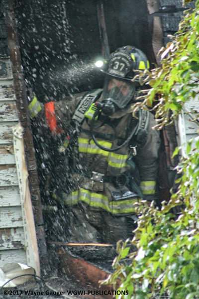 firefighter overhauls after house fire