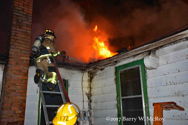 firefighters on ladder battle house fire