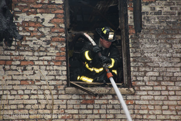 Firefighter with hose line after a fire