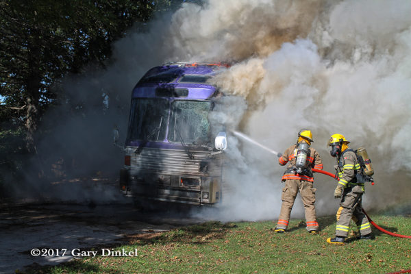 Firefighters battle tour bus fire