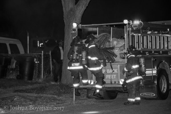 Detoirt firefighters pull hose off the engine