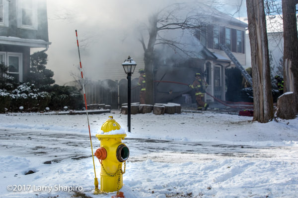 frozen fire hydrant in front of house on fire