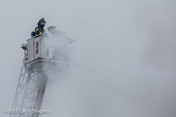 firefighters in tower ladder basket and smoke