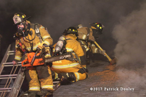 firefighters vent roof at night
