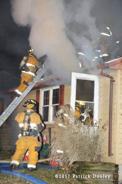 firefighters battle house fire at night