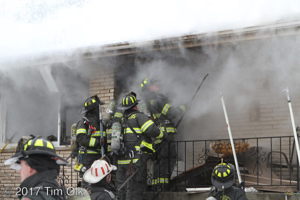 firefighters on front porch with smoke