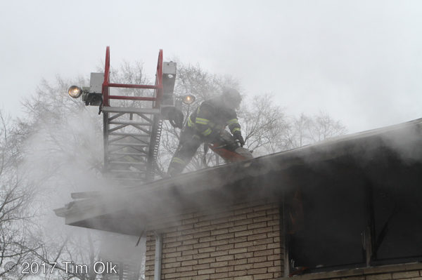 firefighter vents roof in smoke