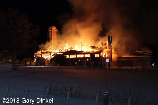 barn fully engulfed in fire at night