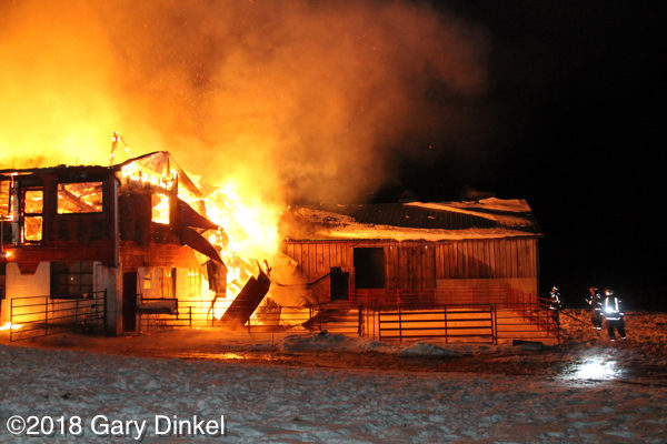 barn fully engulfed in fire at night