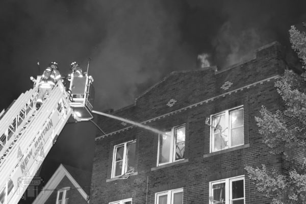 apartment building fire at night with elevated master stream