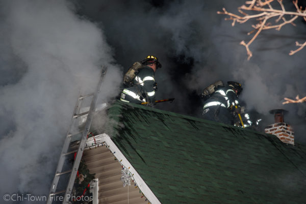 Firefighters on the roof at night with smoke
