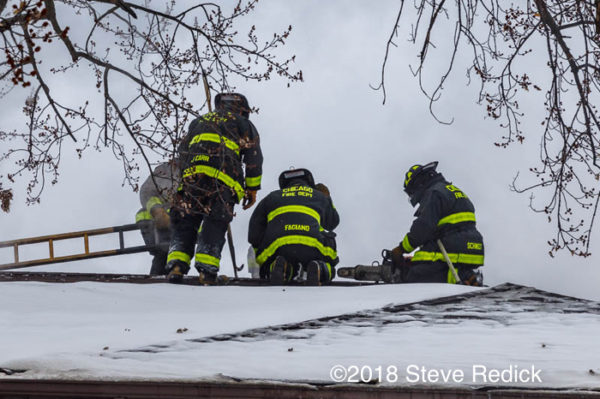 Firefighters on roof with snow