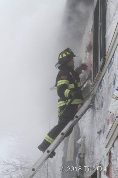 Firefighter on ladder in smoke