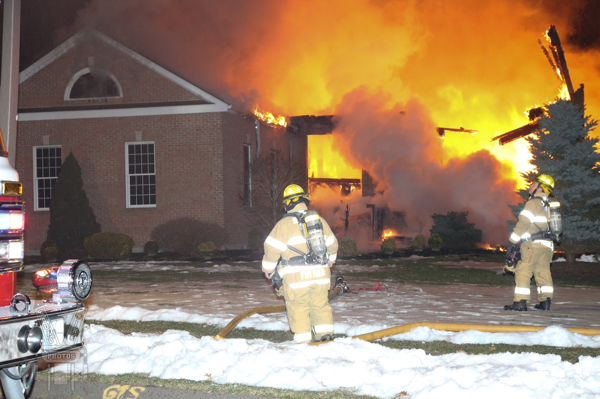 Firefighter at house fire with big flames