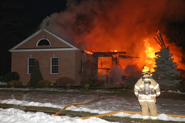 Firefighter at house fire with big flames